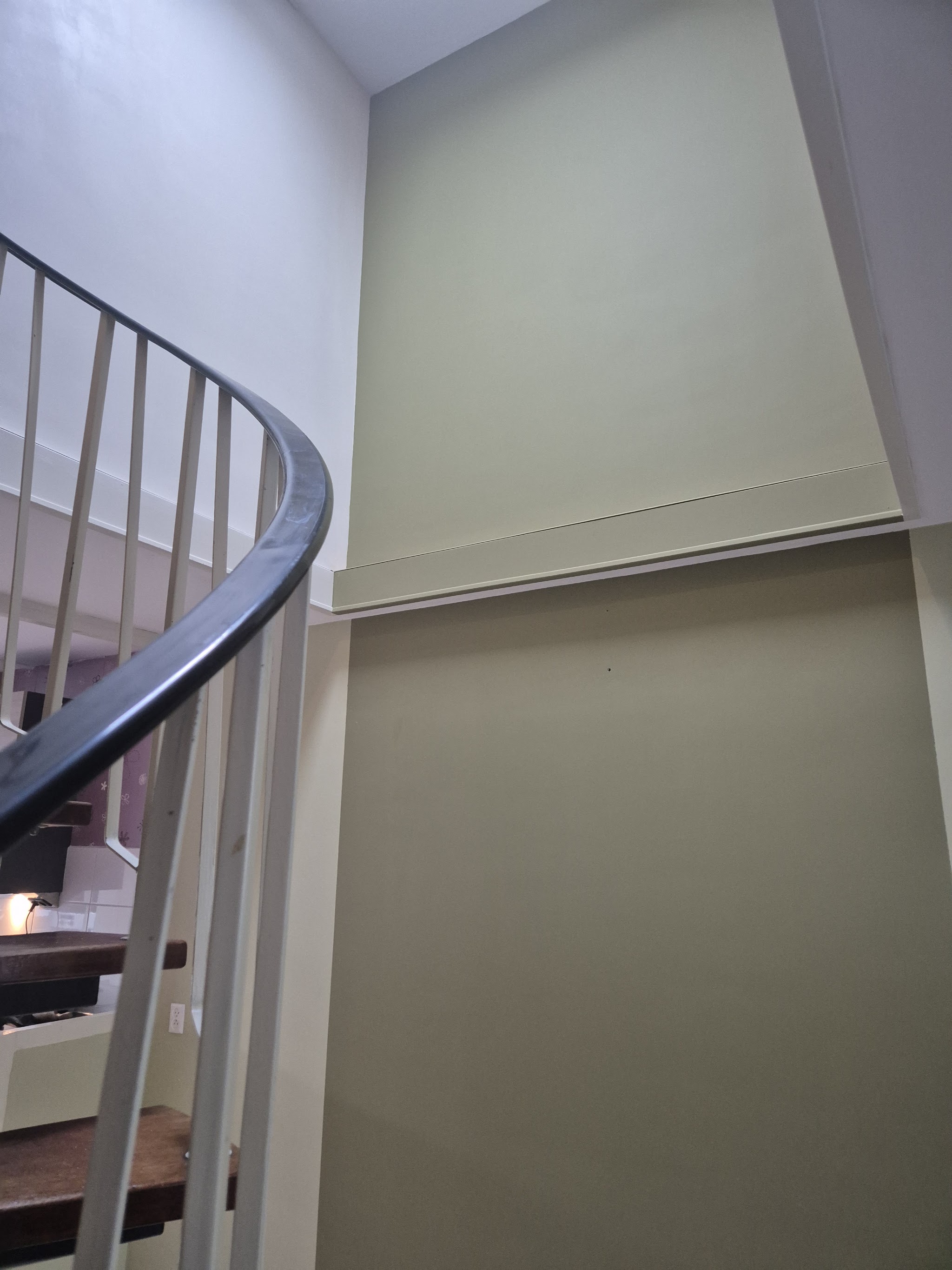 Trappenhuis met een strak gestucte en tweekleurig gesausde wand