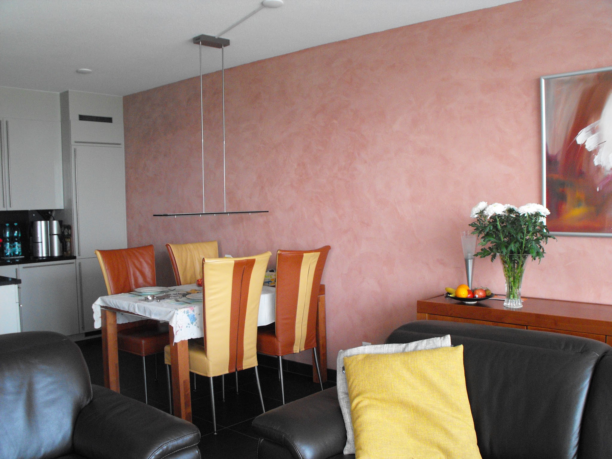 Woonkamer met een zachtroze sierpleister wand